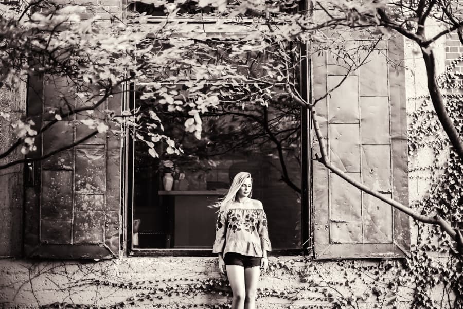 girl standing by wall in alley